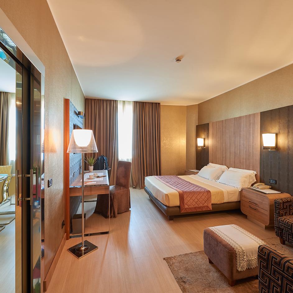 Camera d'hotel con letto matrimoniale e arredi eleganti